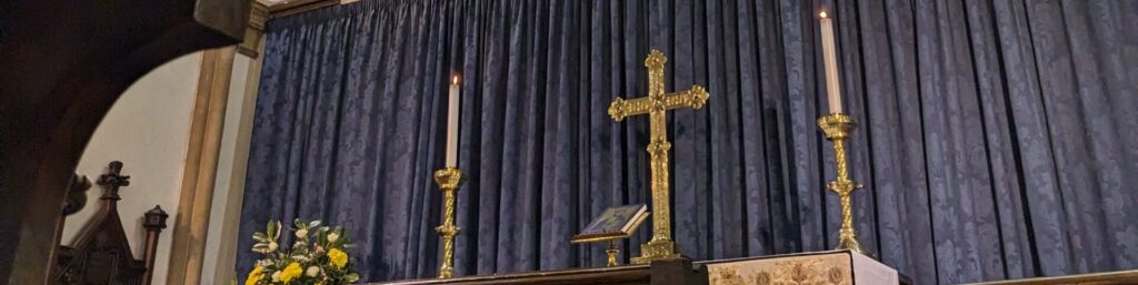 Photo of the altar in St Mary's showing candles and a cross.